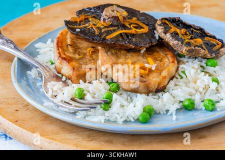 Orange glazed pork escalopes and portobello mushrooms with rice Stock Photo