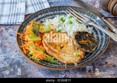 Orange glazed pork escalopes and portobello mushrooms with rice Stock Photo