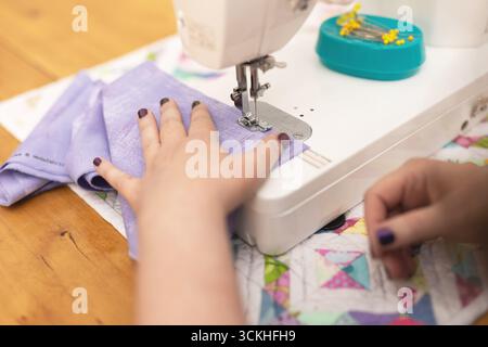 Close up of woman's hands using sewing machine Stock Photo