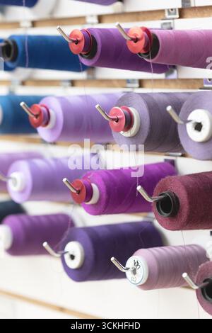 Close up of purple threads on large spools and bobbins Stock Photo