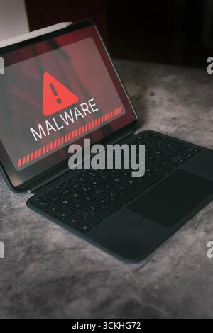 Digital tablet displaying malware alert on screen. Compromised information concept. Internet virus cyber security and cybercrime. Stock Photo