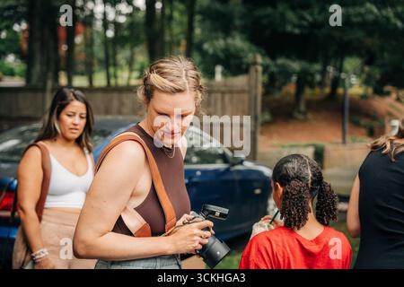 Female photographer reviewing photos on camera during photoshoot Stock Photo