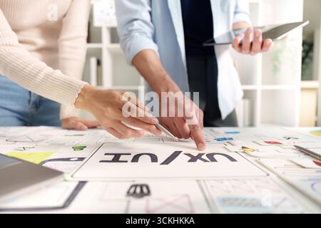 Hands-on UXUI Design Review. Team members collaborating on interface design concepts. Stock Photo