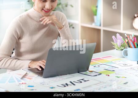 UXUI Designer Engaged in Digital Project. Focused professional working on laptop in creative environment. Stock Photo