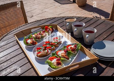 Delicious bite-sized snacks arranged on a tray with beverages, set on a wooden table, ideal for casual sharing and enjoying during gatherings and part Stock Photo