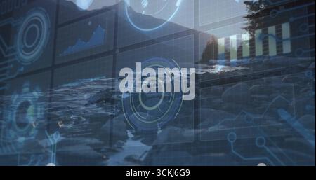 Displaying translucent interface overlay over rocky shoreline at sunset, with HUDs and line charts Stock Photo
