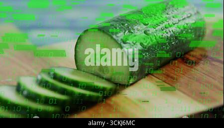 Displaying half cucumber resting on board at kitchen counter, with slices and binary code overlay Stock Photo