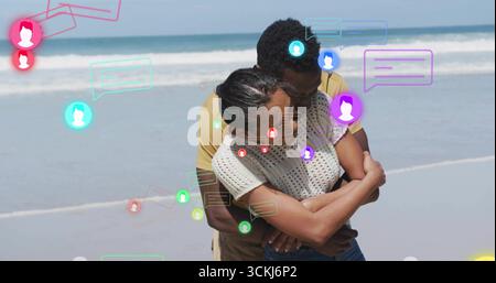 Embracing couple wearing casual clothes hugging on shore with floating chat bubbles and avatars Stock Photo