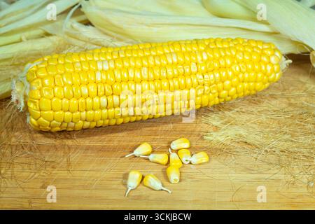 Tutu of corn peeled on a wooden board with grains. One Stock Photo