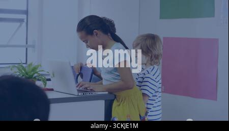 Typing girl wearing shirt and yellow skirt using laptop in school classroom, with poster boards Stock Photo