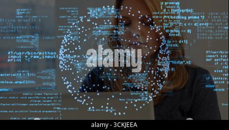 Working software developer coding on laptop in workspace, with blue code data visualization network Stock Photo