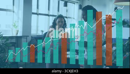Three professionals wearing work clothes analyzing overlay charts in office with laptop and tablet Stock Photo