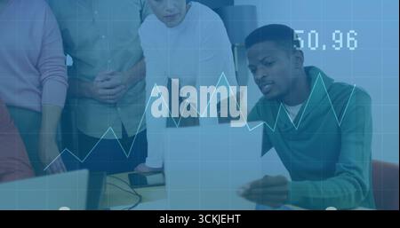Collaborating team reviewing laptop financial data in office meeting room with line chart overlay Stock Photo
