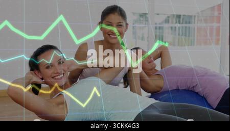 Three women doing abs workout in gym studio, with colored mats, stability ball, translucent overlay Stock Photo