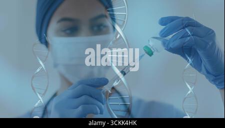 Lab tech wearing mask gloves drawing liquid from vial preparing syringe in lab, with DNA graphics Stock Photo