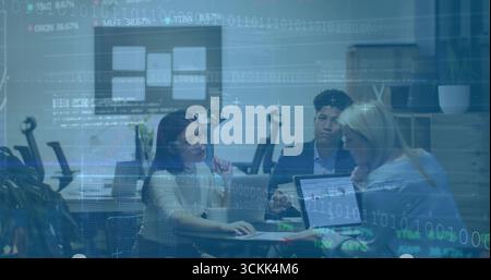 Collaborating professionals in business attire reviewing laptop and monitor in conference room Stock Photo