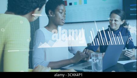 Analyzing data on laptop in conference room with tablet, displaying bar charts on display screen Stock Photo