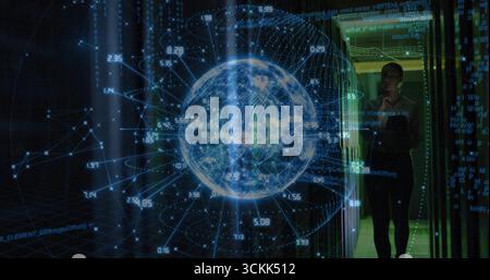 IT specialist examining holographic Earth globe in server room, with numeric data overlay Stock Photo