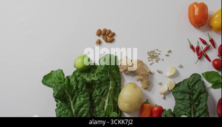 Displaying Swiss chard, ginger and almonds in flatlay on white countertop, showing colorful produce Stock Photo