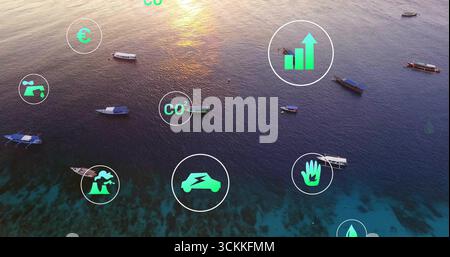 Displaying translucent green sustainability icons hovering over tropical sea at sunset, with boats Stock Photo