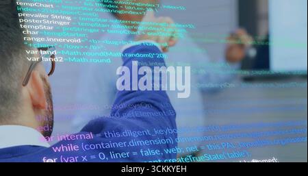 Reviewing code, two engineers collaborating on monitor in meeting room, with code overlays Stock Photo