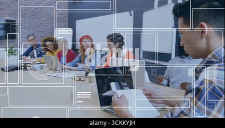 Collaborating office professionals in sweaters discussing papers in conference room, with laptops Stock Photo