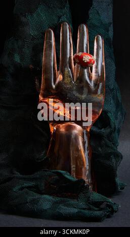 Glass ring holder with a red ring and black lace background. Stock Photo