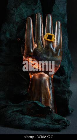 Glass hand ring holder with a black onyx ring and black lace background. Stock Photo