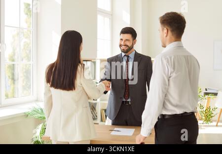 Office confident diverse business people, men and woman shaking hands in office, smiling Stock Photo