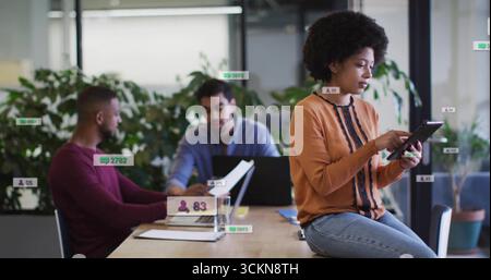 Colleagues in business attire collaborating at office table, with devices and documents, copy space Stock Photo