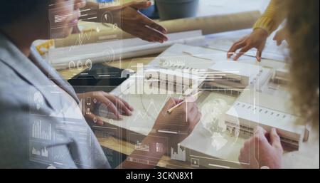 Team in business wear sketching building model in studio, with blueprints, pencils and data overlay Stock Photo