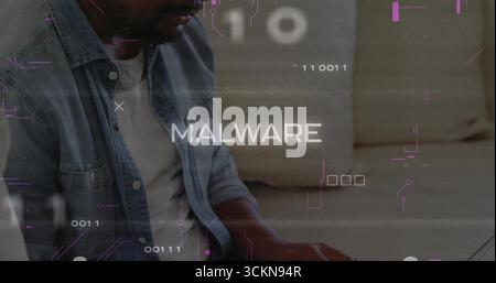 Typing man wearing denim jacket analyzing MALWARE binary code on laptop in living room, copy space Stock Photo