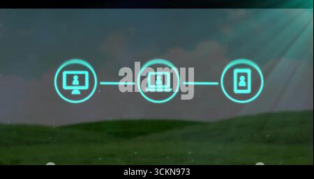 Floating three neon device icons connecting with glowing lines over grassy hill in digital sky Stock Photo