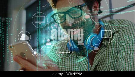 Smiling bearded man tapping smartphone screen in tech workspace, with holographic network icons Stock Photo