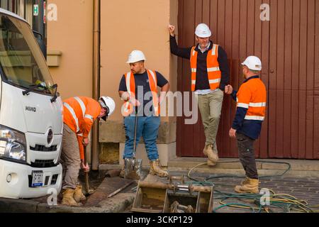 Team of construction workers wearing safety gear collaborating and actively assisting each other during a project, The Rocks, Sydney Stock Photo