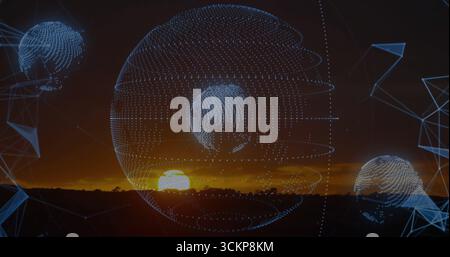 Showing central and smaller wireframe globes hovering over plain at sunset, with blue mesh shapes Stock Photo