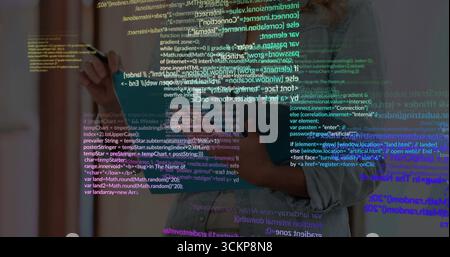 Developer wearing denim shirt writing code on glass panel in office with marker pen, copy space Stock Photo