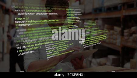 Scanning racks and boxes, employee wearing white shirt and hard hat using tablet inside warehouse Stock Photo