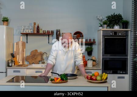 The chef is skillfully preparing vibrant ingredients in a modern kitchen, showcasing artistry Stock Photo