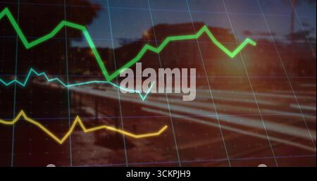 Displaying tri color line graph curves over gridlines, blurred rural railway at dusk with sun flare Stock Photo
