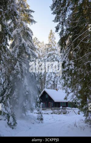 Enchanting winter sunset over a cozy cabin nestled in the Black Forest of Forbach, Germany Stock Photo
