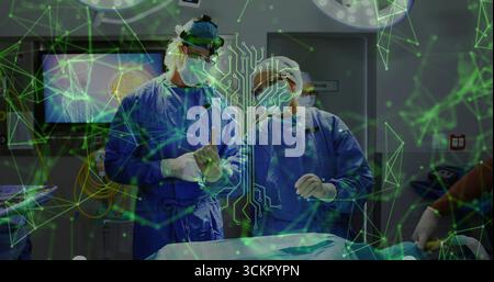 Two surgeons wearing blue scrubs performing brain surgery in operating theater, using AR overlay Stock Photo
