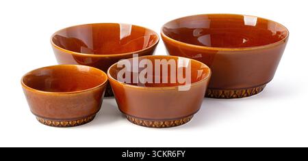 Four brown ceramic bowls of different sizes forming a set, isolated on white background Stock Photo