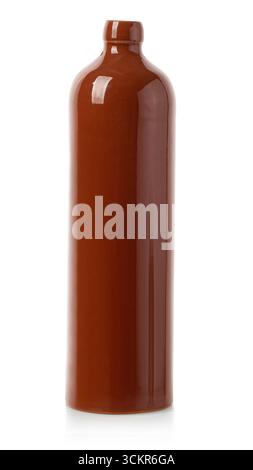 Shiny brown ceramic bottle standing on a reflective white background Stock Photo