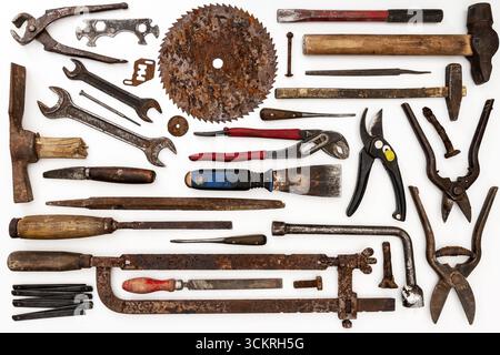 Flat lay of old hand tools on white background. Large collection of various rusty tools and bits arranged on white. Stock Photo