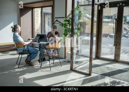 Two knowledgeable professionals collaborating effectively together in a modern workspace setting Stock Photo