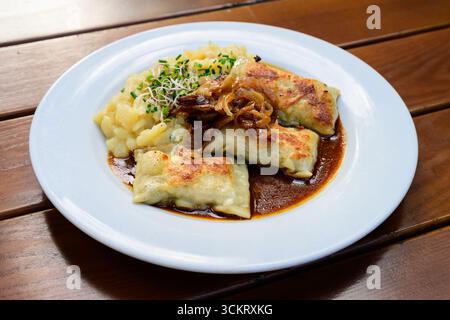 Maultaschen German Meat Filled Dumplings or Pasta with Gravy Sauce and Potato Salad Stock Photo