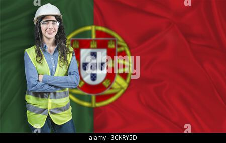 Young female construction engineer with Portugal flag. Portrait of smiling female engineer with Portuguese flag in background Stock Photo