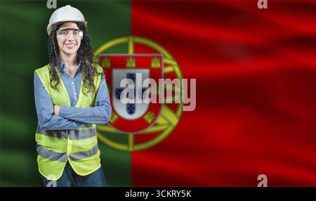 Portrait of smiling female engineer with Portuguese flag in background. Young female construction engineer with Portugal flag Stock Photo