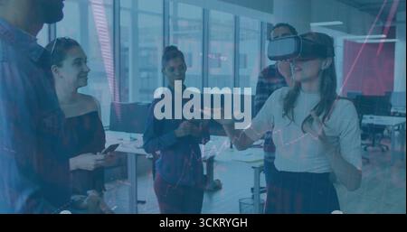 Gesturing woman wearing VR headset interacting with financial graphs in tech office, copy space Stock Photo